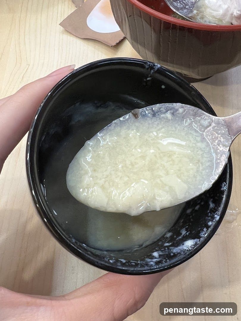 Hand holding spoon with soup