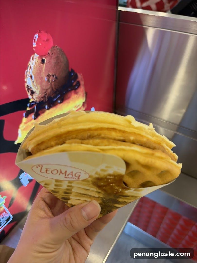 Hand holding waffle in branded paper cone