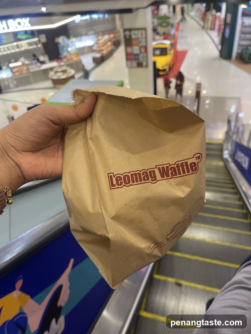 Hand holding Leomag Waffle bag on escalator