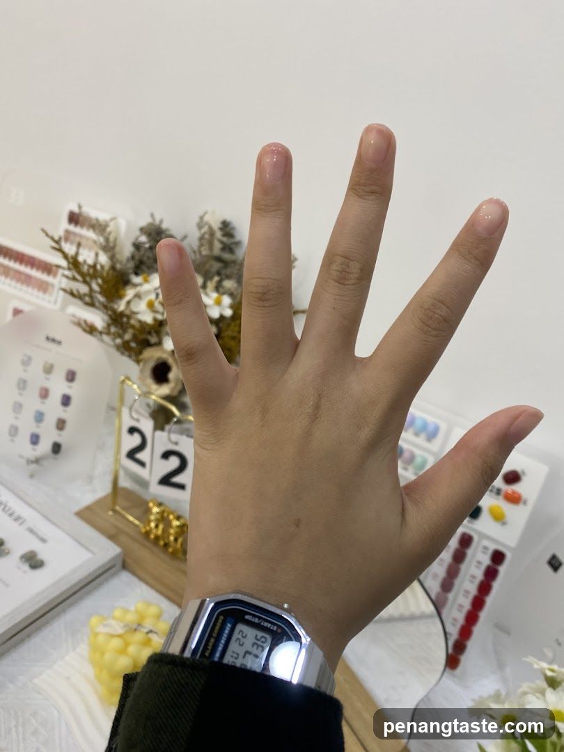 Hand with digital watch in nail salon setting