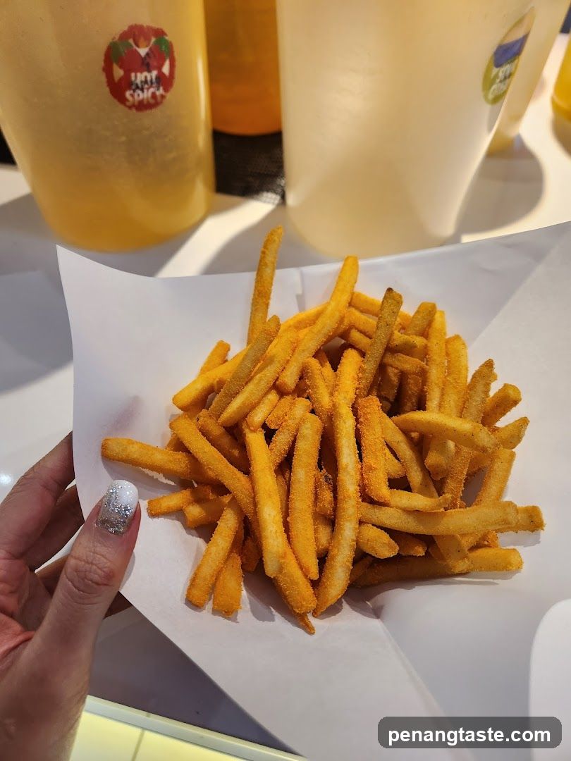 Hand holding fries with condiment bottles