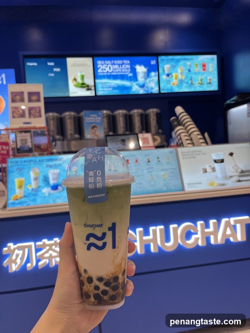 Hand holding a CHUCHAT drink in front of counter