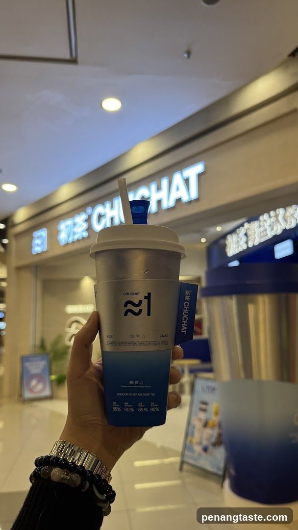 Hand holding CHUHCHAT drink in shopping mall