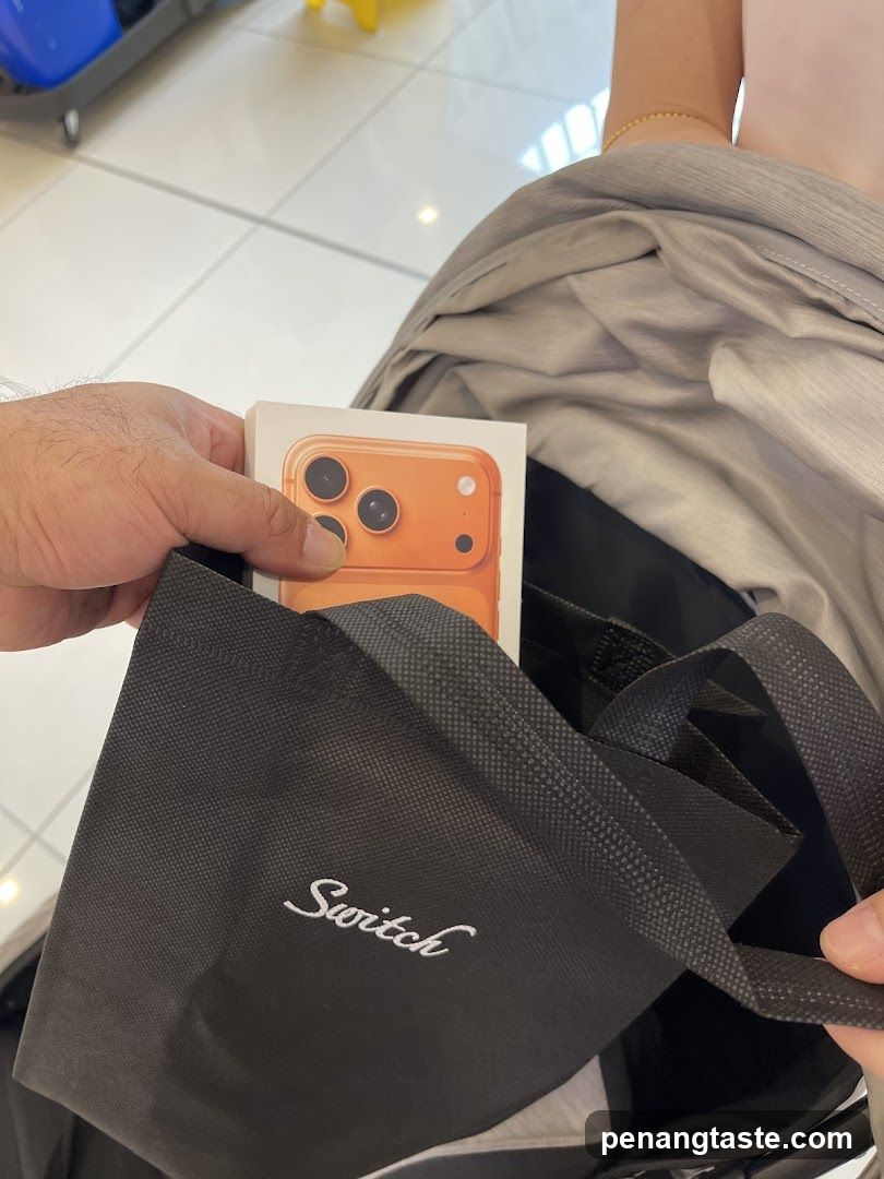 Hand holding phone box and branded bag