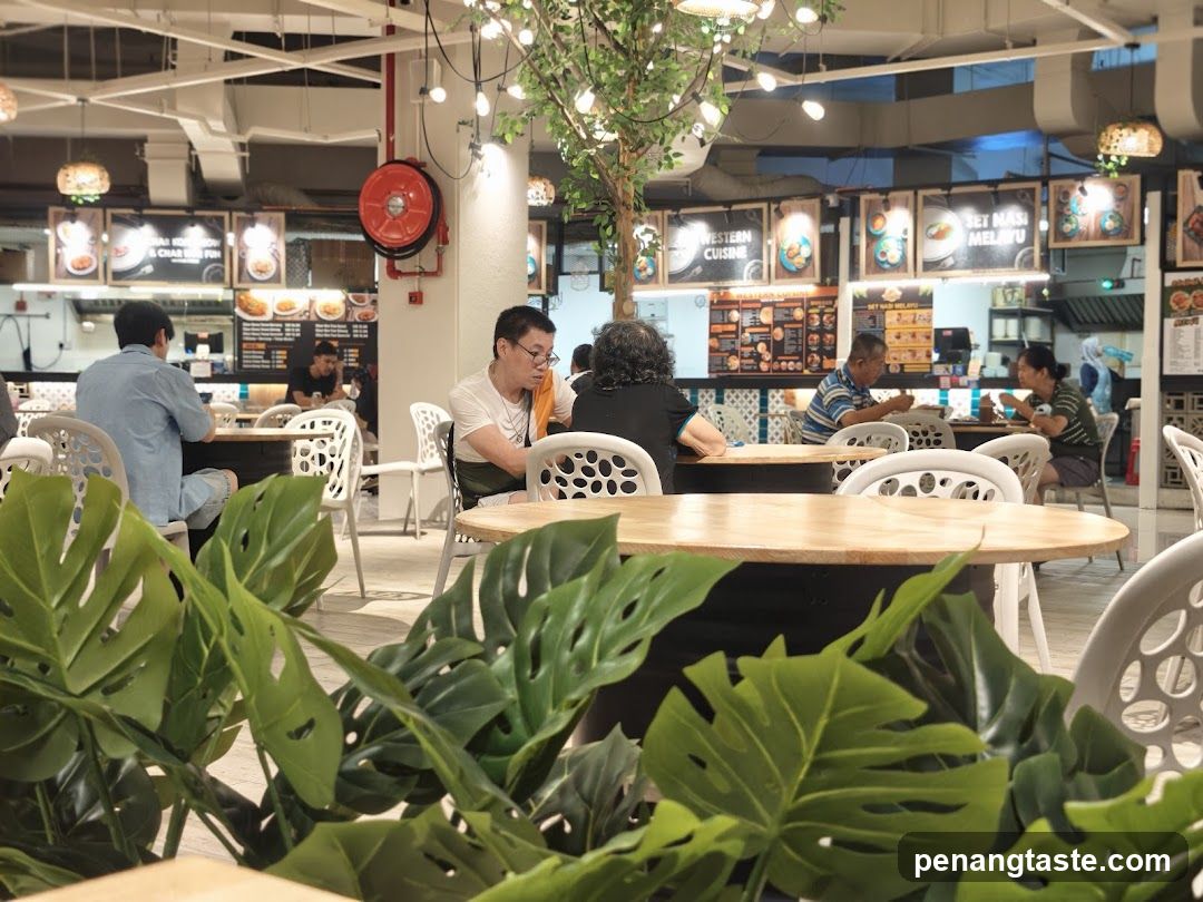 Indoor dining area with patrons and greenery