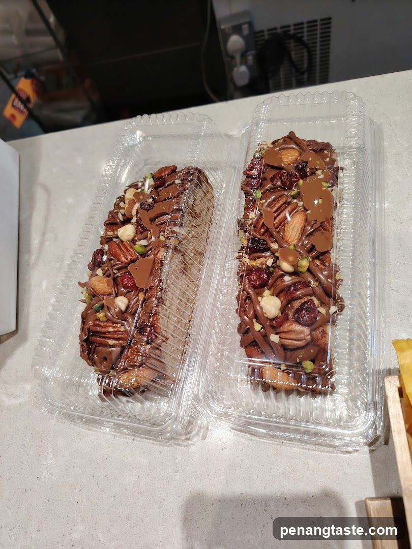 Two chocolate-covered nut bars in clear plastic containers