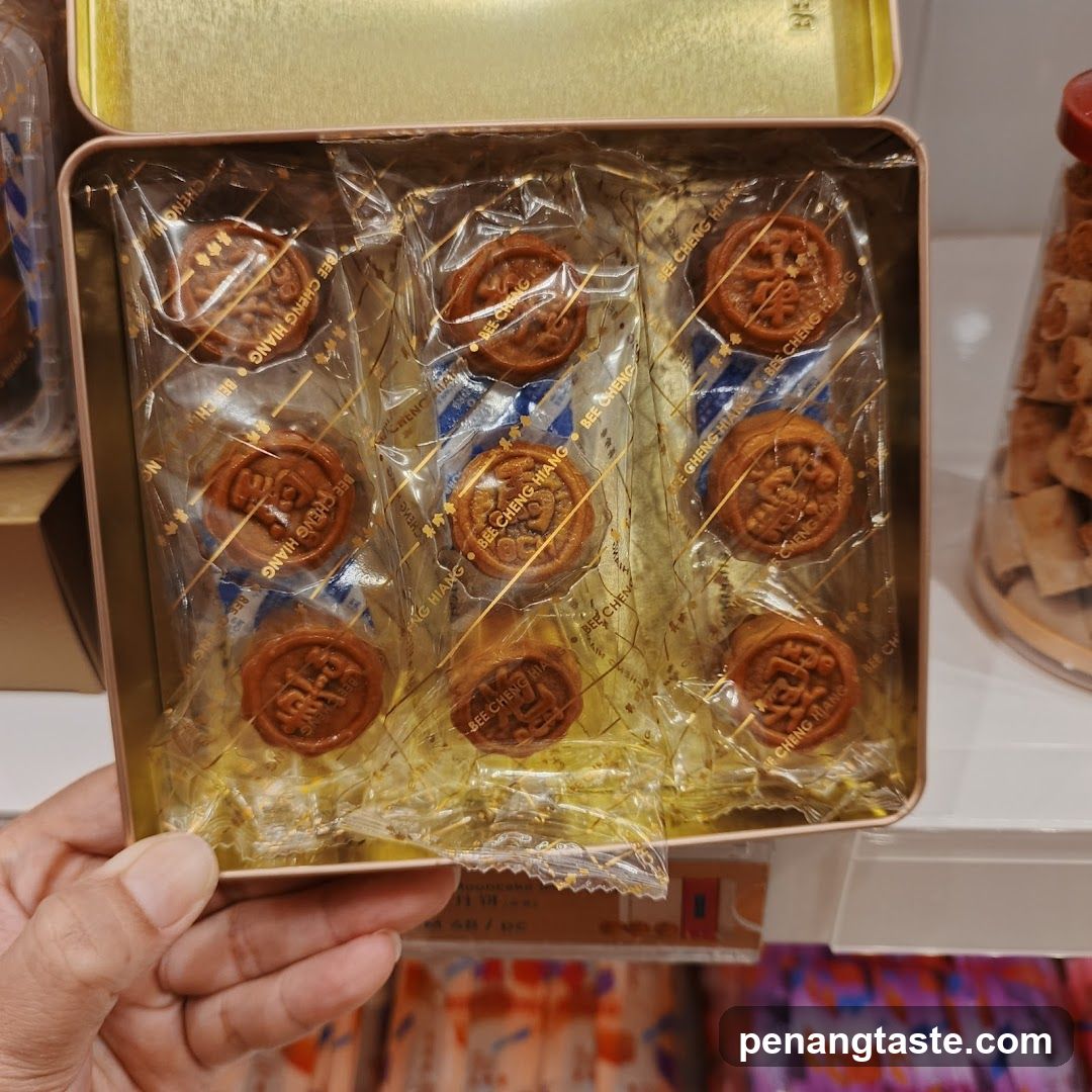 Hand holding a tin of packaged mooncakes