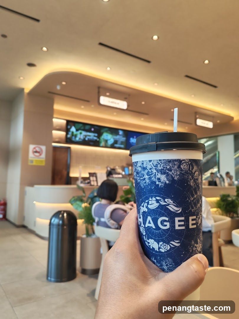 Hand holding beverage cup inside a café or lounge