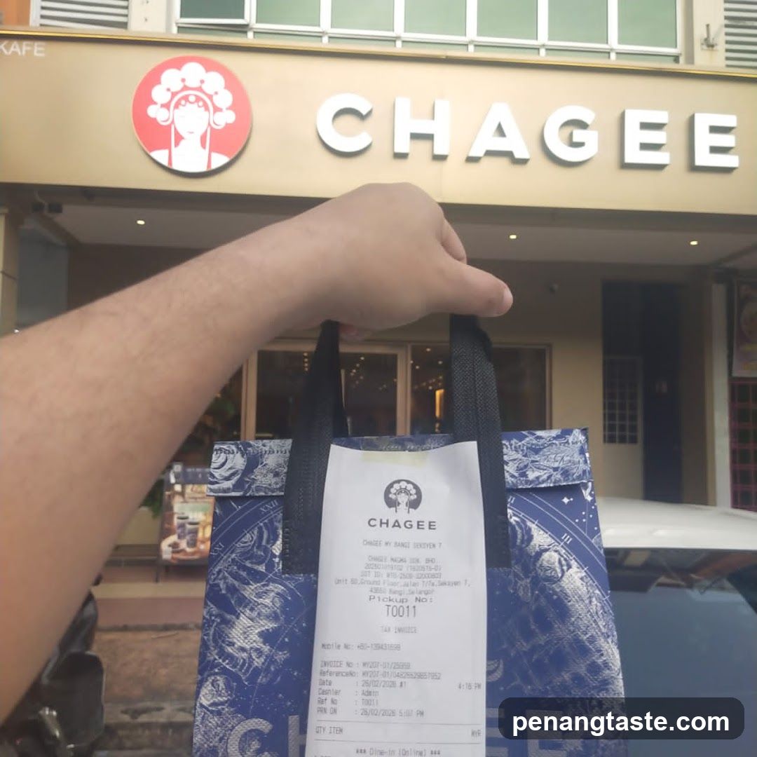 Hand holding Chagee bag in front of storefront