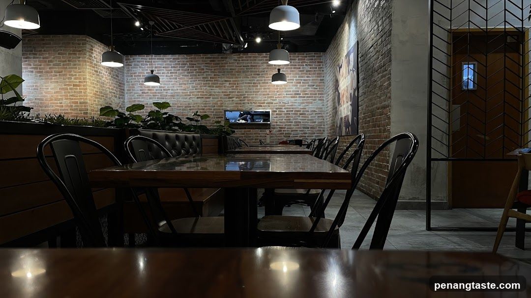 Interior of a modern restaurant or cafe with brick walls and wooden tables.
