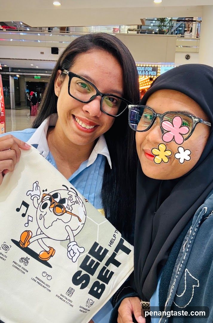 Two women holding a tote bag in a mall