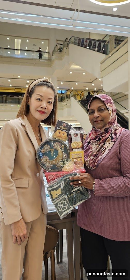 Two women holding gift items in a mall