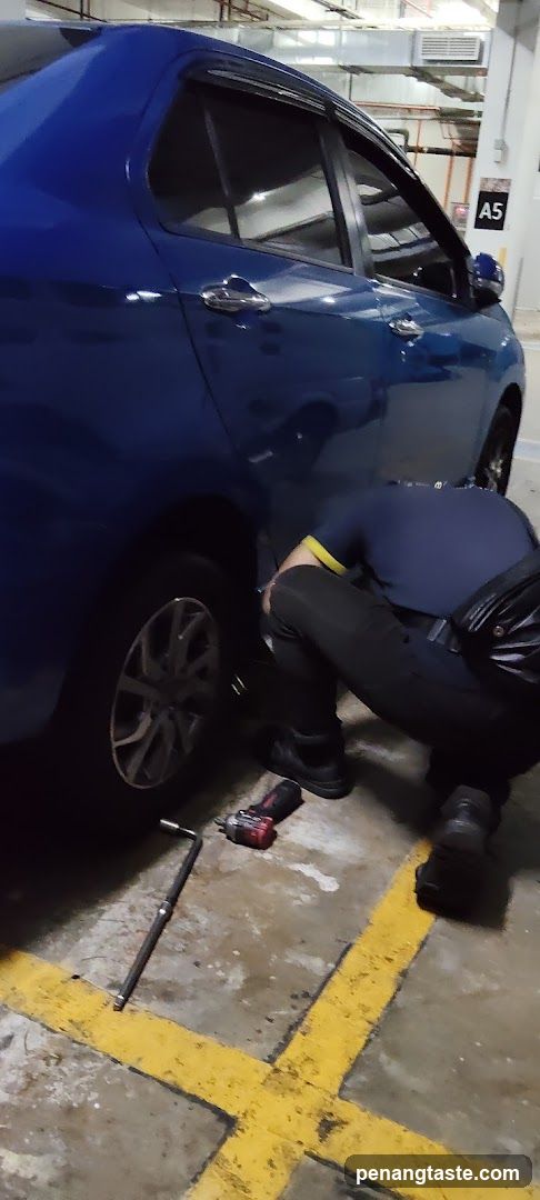 Mechanic Working on Car in Parking Garage