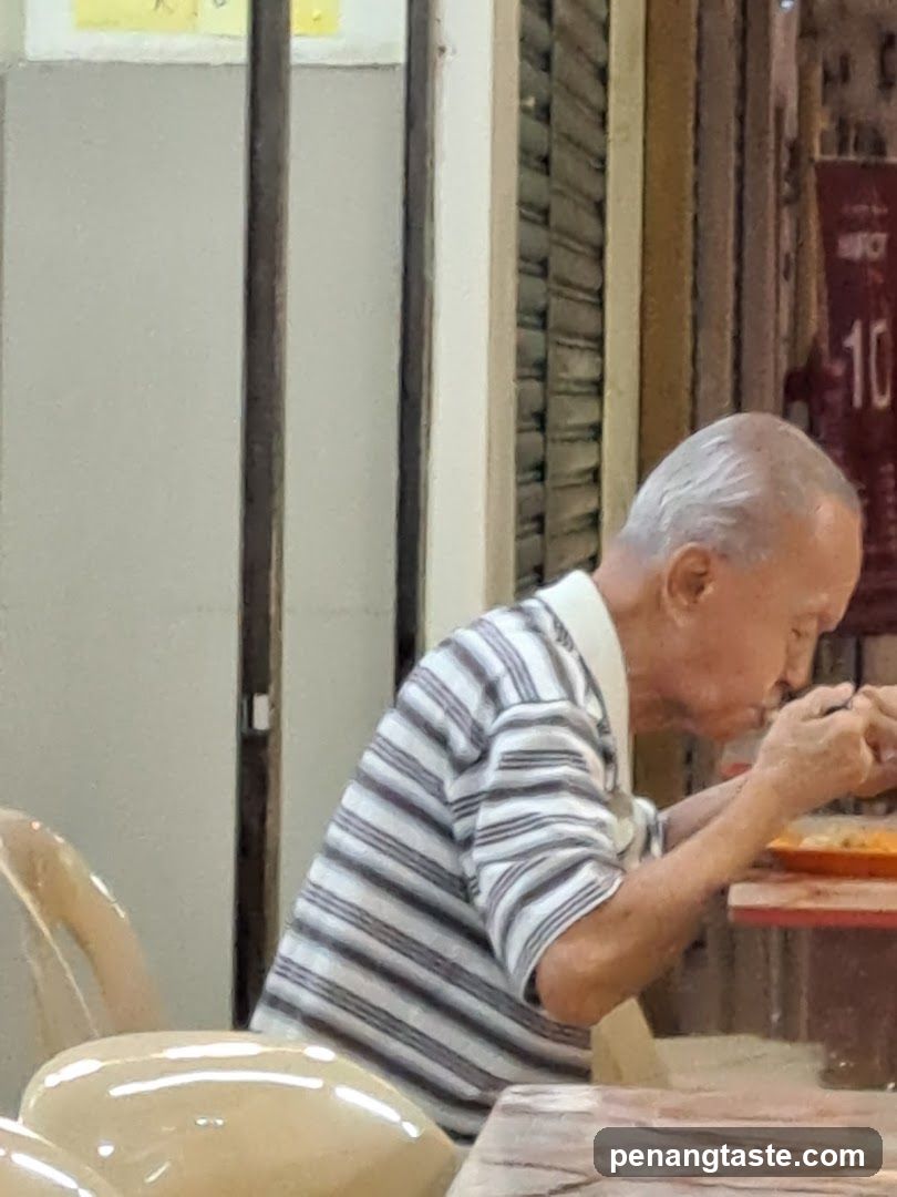 Elderly man eating at a table