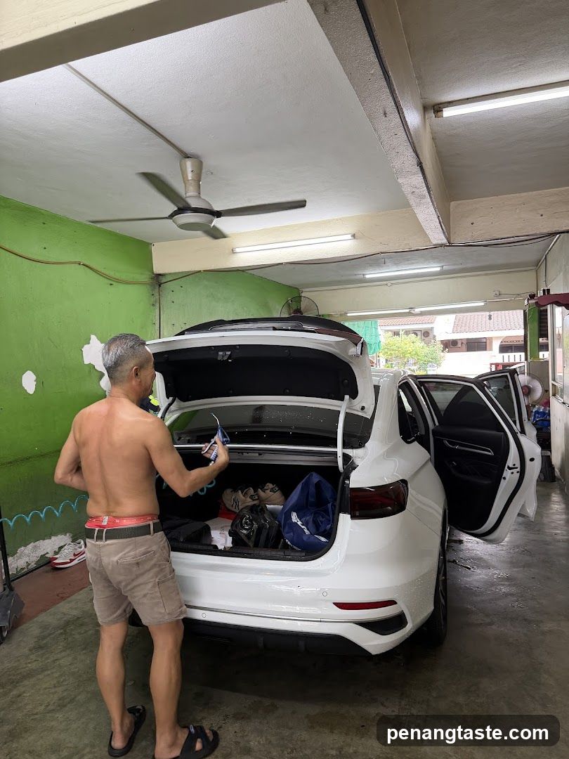 Man organizing car trunk in garage