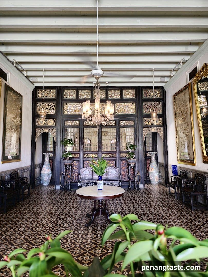 Interior of a traditional-style room with ornate wooden screens and patterned floor tiles.