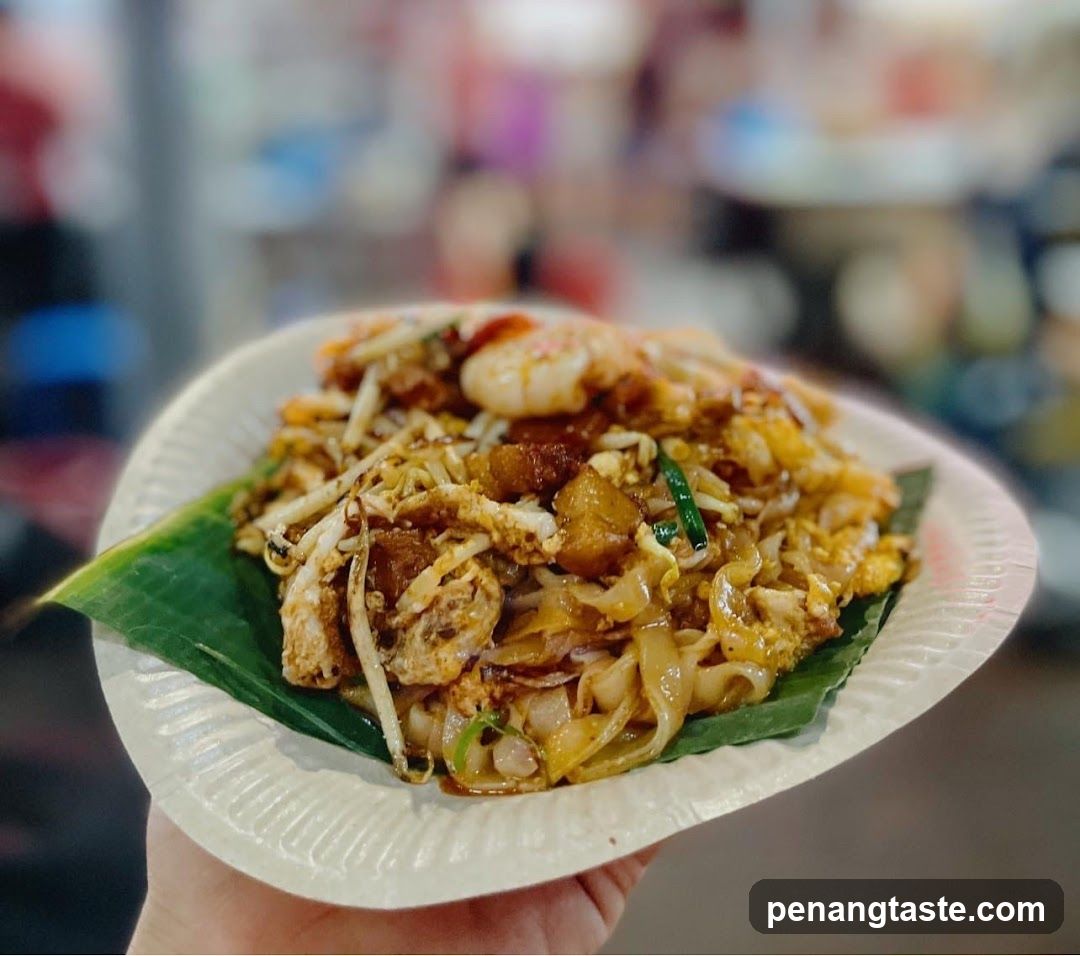 Hand-held plate of stir-fried noodles with shrimp and egg