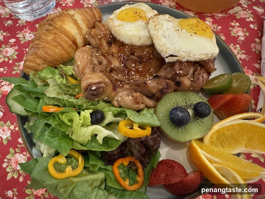 Breakfast Plate with Croissant, Fried Eggs, Chicken, Salad and Fruit