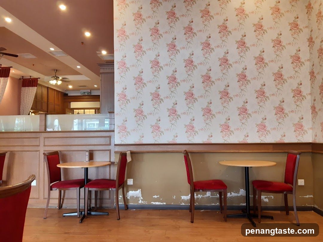 Interior of a cafe or restaurant with floral wallpaper and red chairs