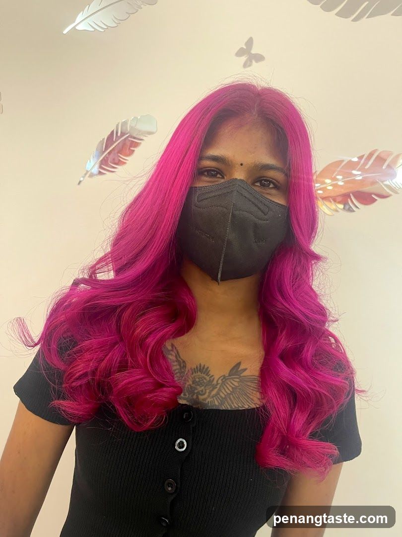 Person with pink hair and mask