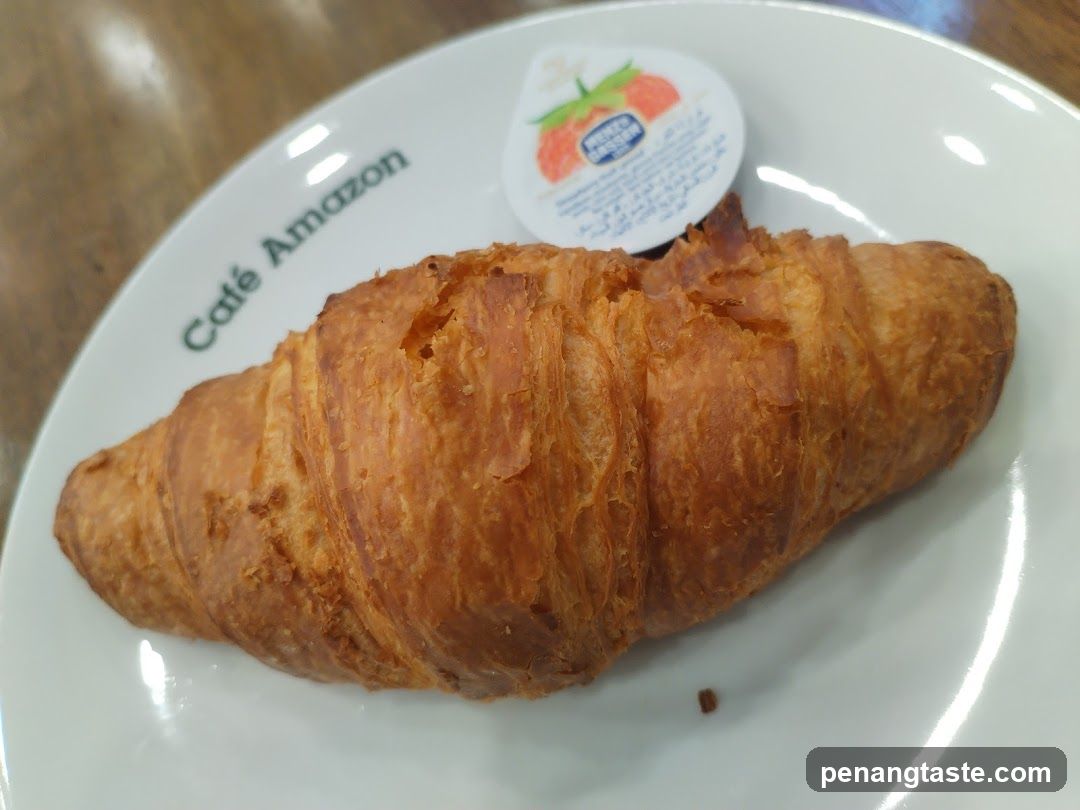 Croissant on a plate with yogurt cup