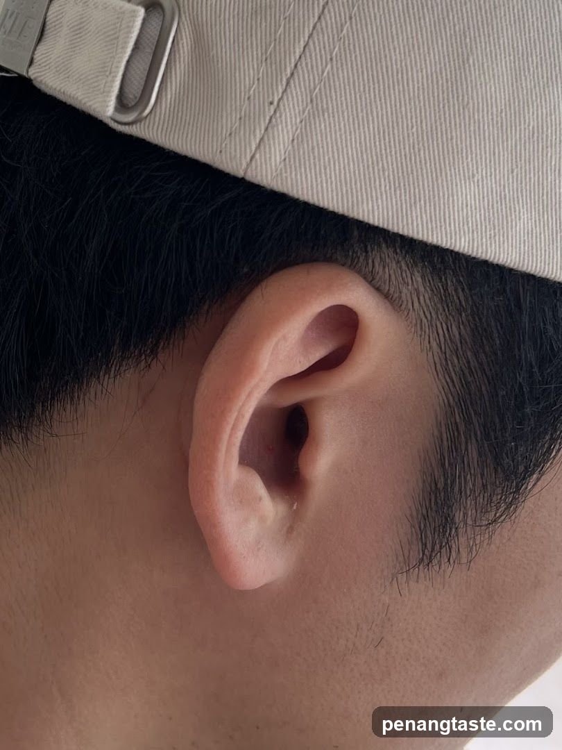 Side view of a person's ear wearing a cap