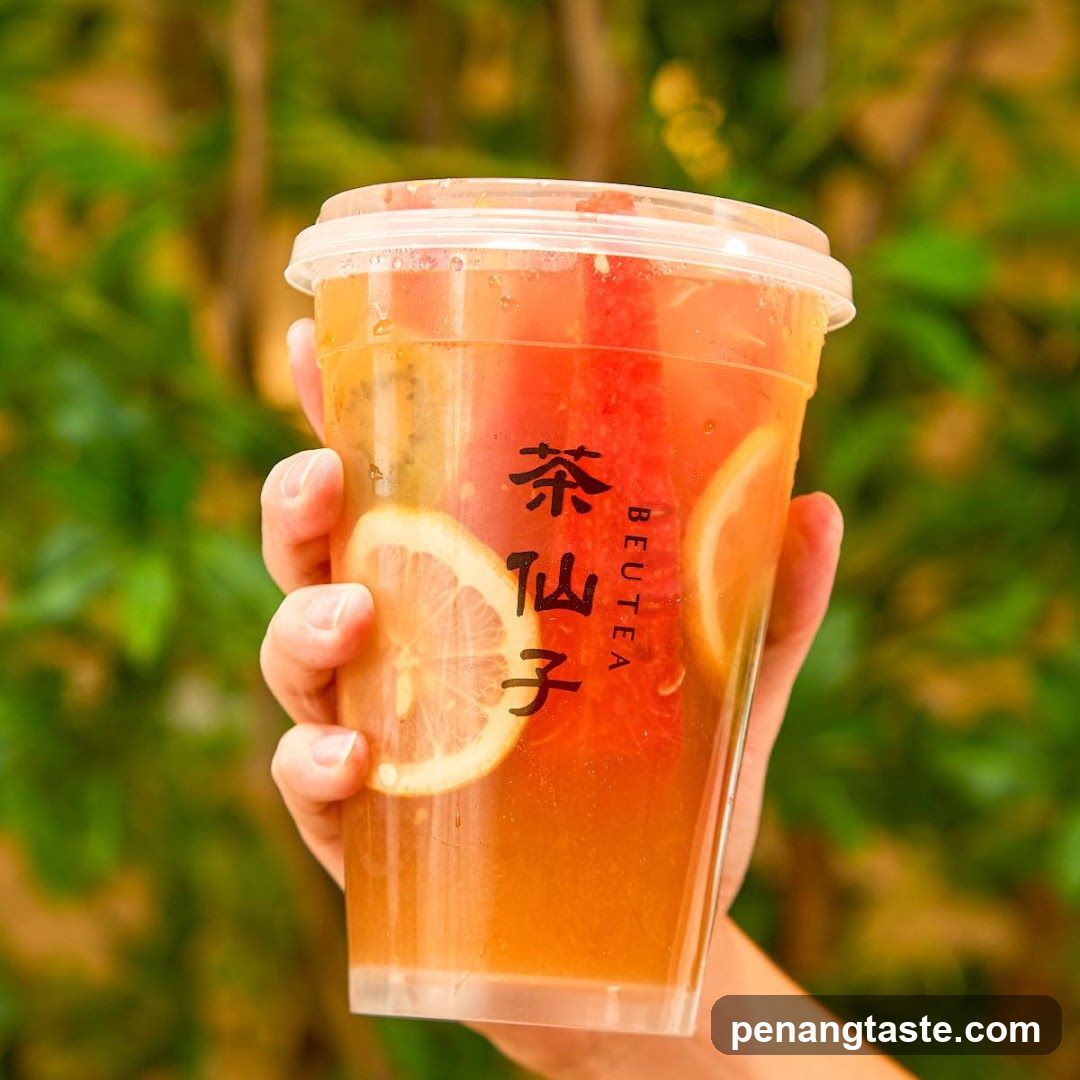 Hand holding a cup of tea with lemon slices