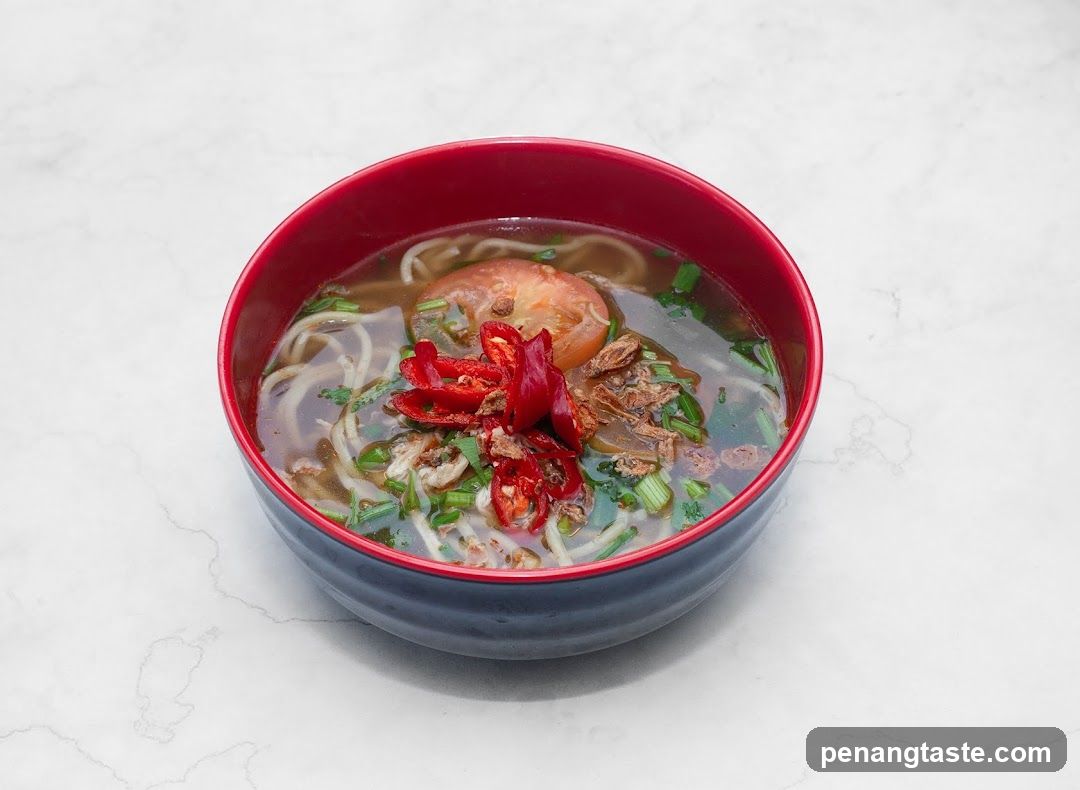 Bowl of Noodle Soup with Tomatoes and Chili Peppers