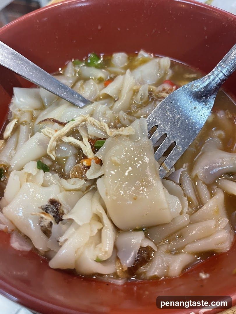 Bowl of Noodle Soup with Fork and Spoon