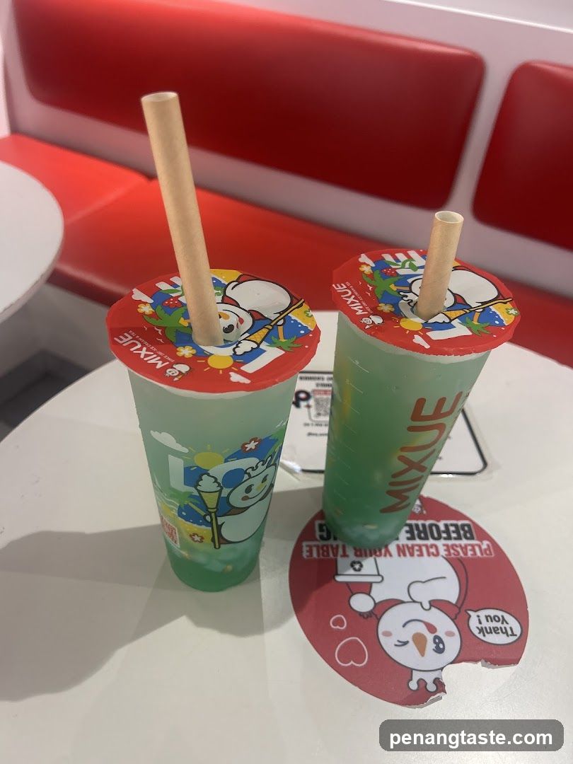 Two green bubble tea drinks with straws on a table