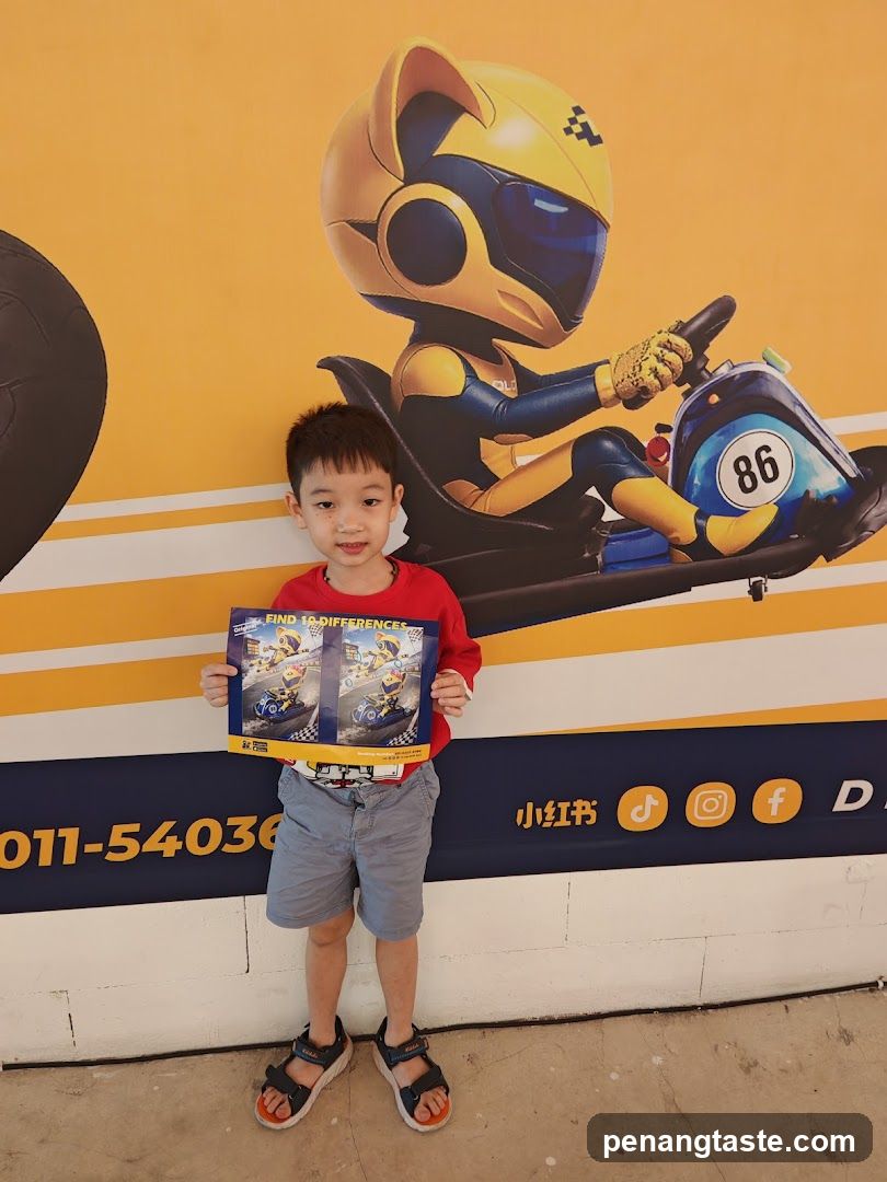 Child holding a go-kart themed box in front of a wall mural