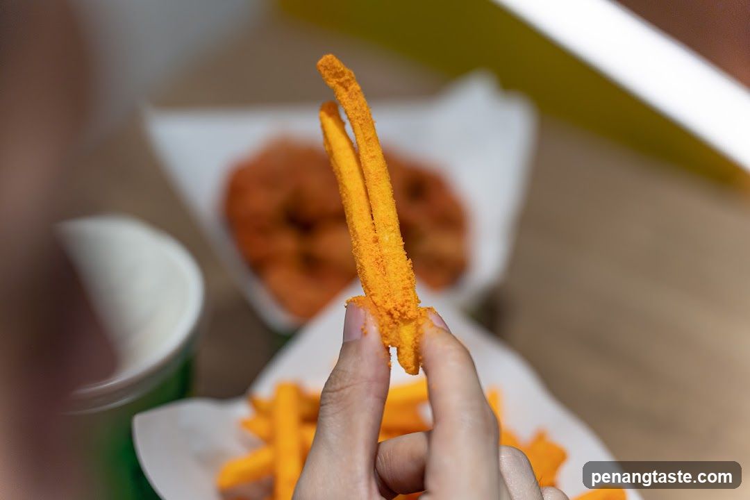 Hand Holding Crispy Fries with Side Dish