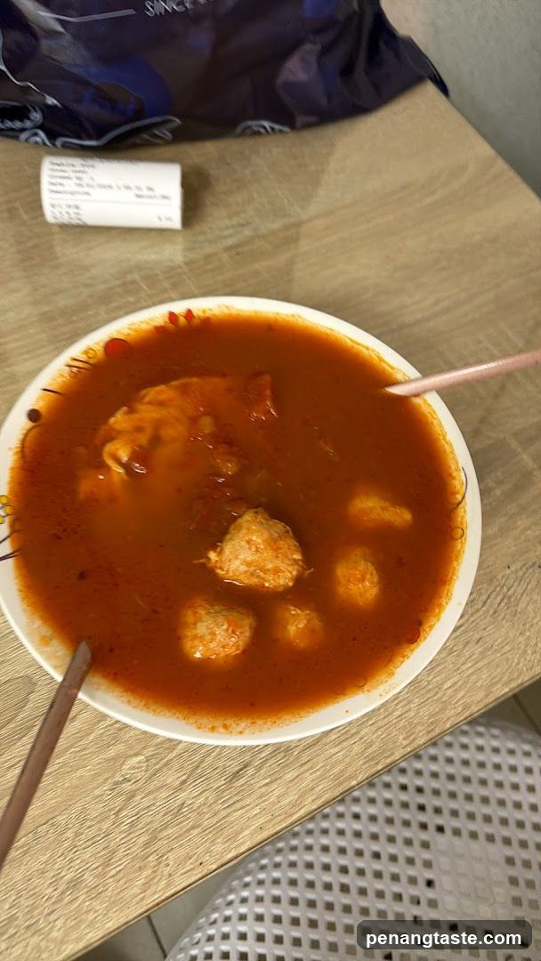 Bowl of Red Soup with Meatballs