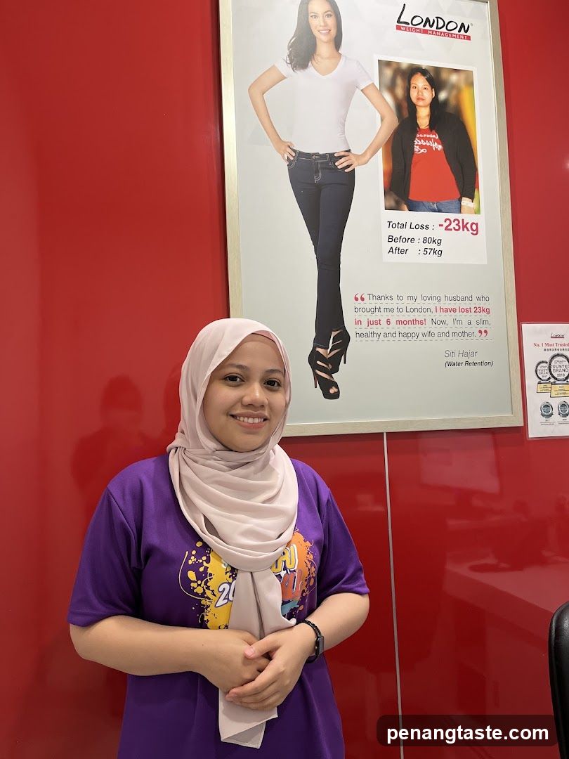 Woman in purple shirt and hijab standing in front of a poster