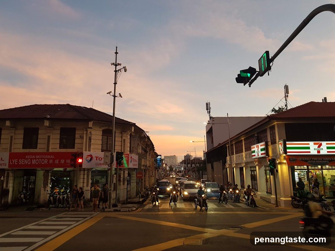 Street scene at dusk with traffic and shops