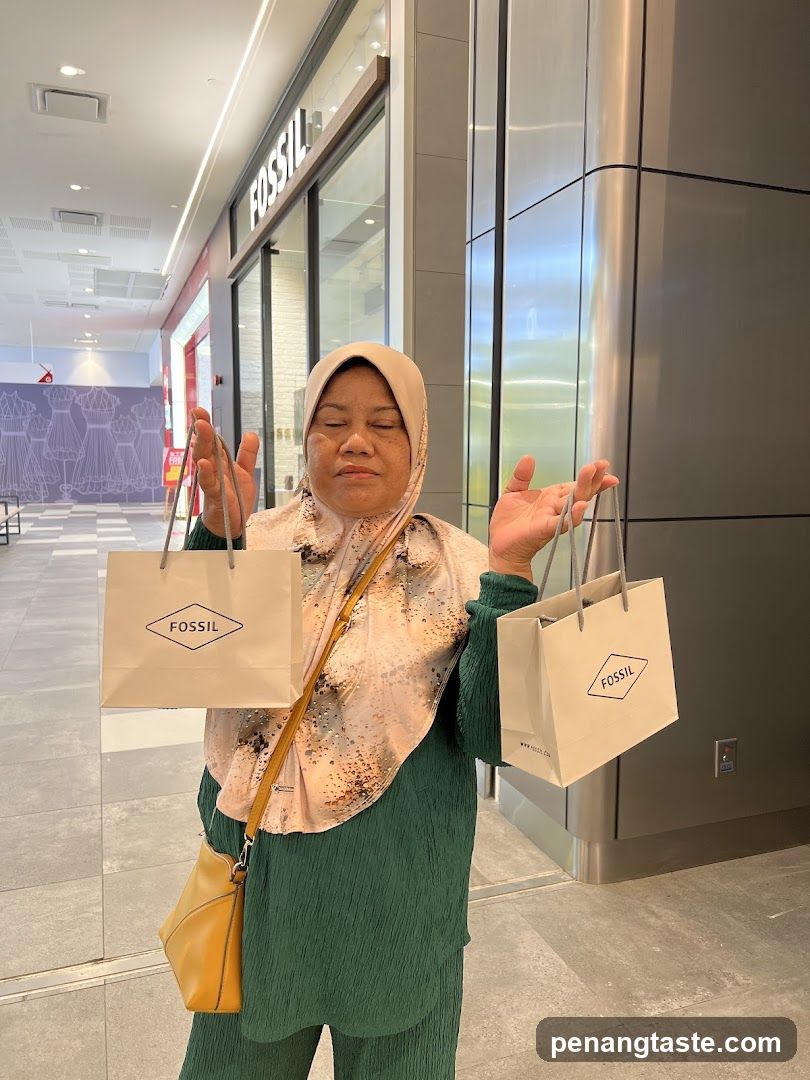 Woman holding Fossil shopping bags in mall