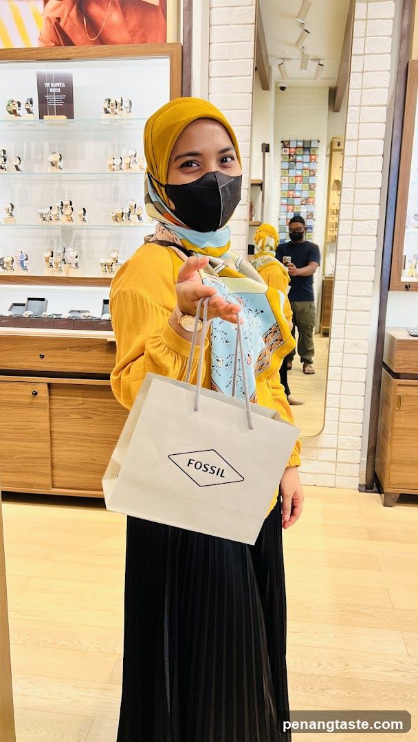Woman holding Fossil shopping bag in store