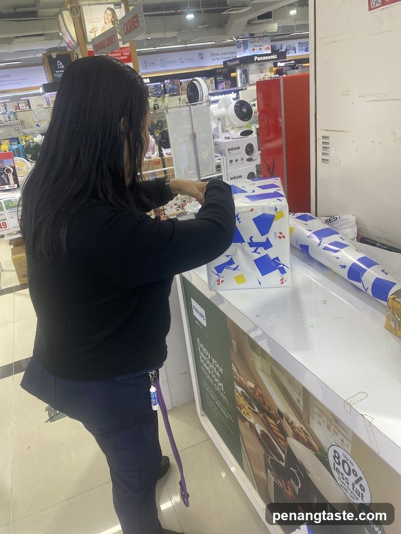 Woman wrapping gift in electronics store
