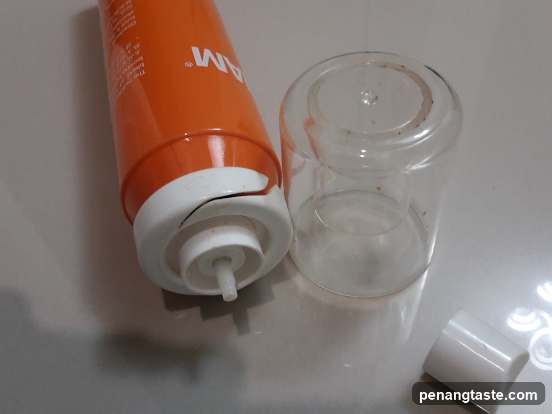 Orange tube and clear container on surface
