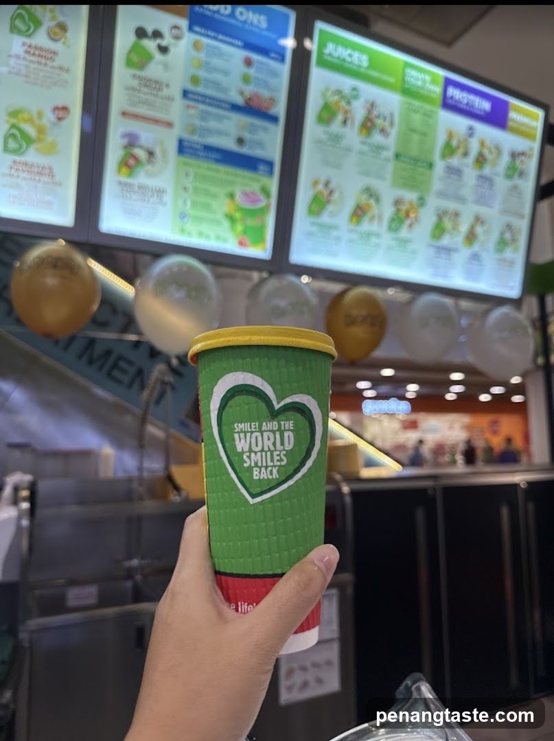 Hand holding green cup with heart slogan