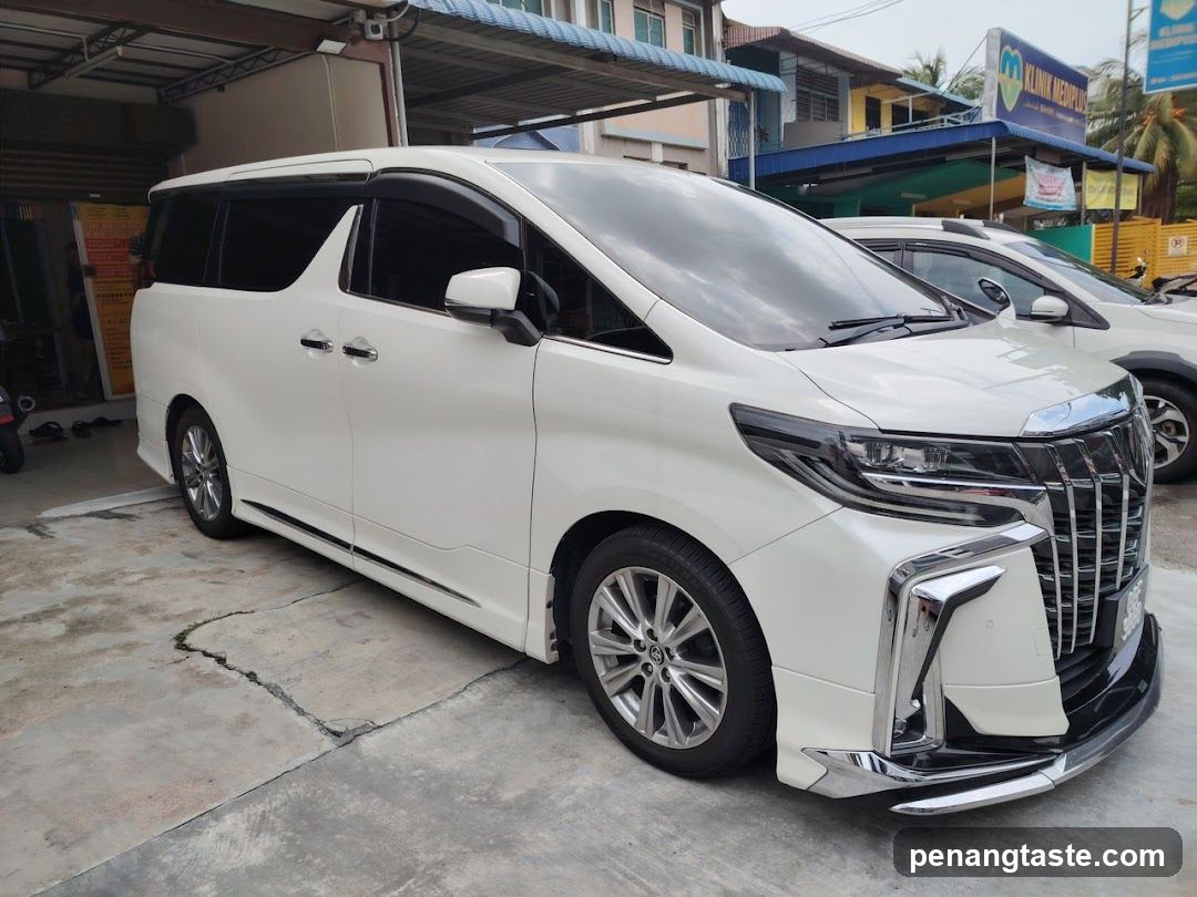 White Toyota Alphard parked outside shop