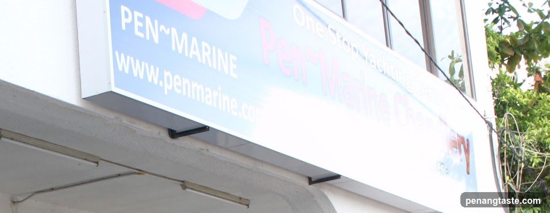 A close-up view of a shop sign mounted on the exterior wall of a building. The sign reads 'PEN~MARINE' and includes the website 'www.penmarine.com'. Additional text mentions 'One Stop Yachting Supplies' and 'Pen~Marine Chemicals', indicating it is likely a marine supply store.