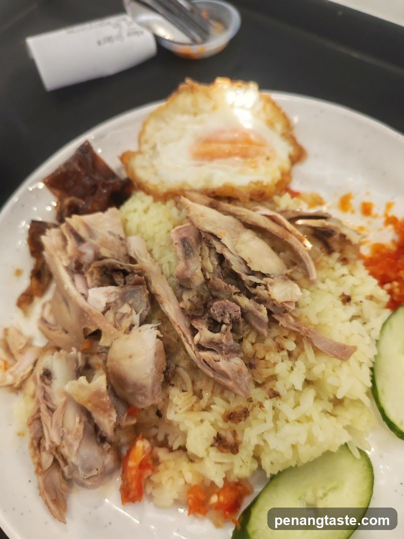 Plate of Chicken Rice with Fried Egg and Cucumber