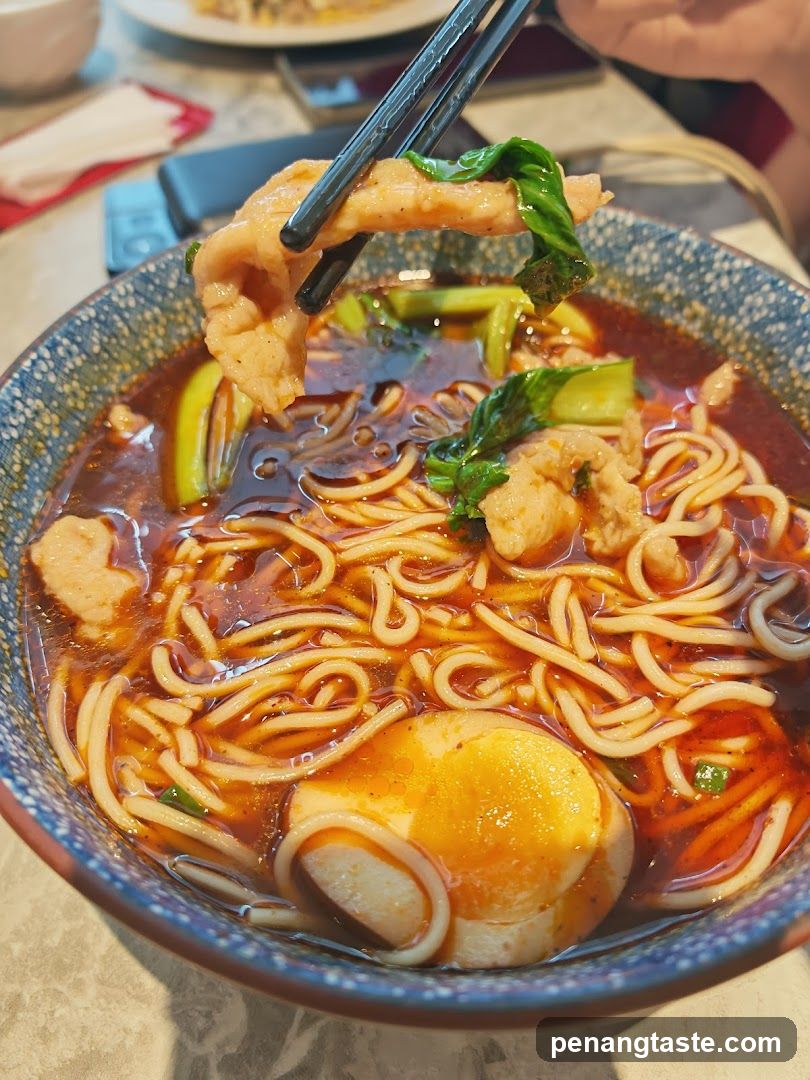 Spicy Noodle Bowl with Halved Egg and Chicken