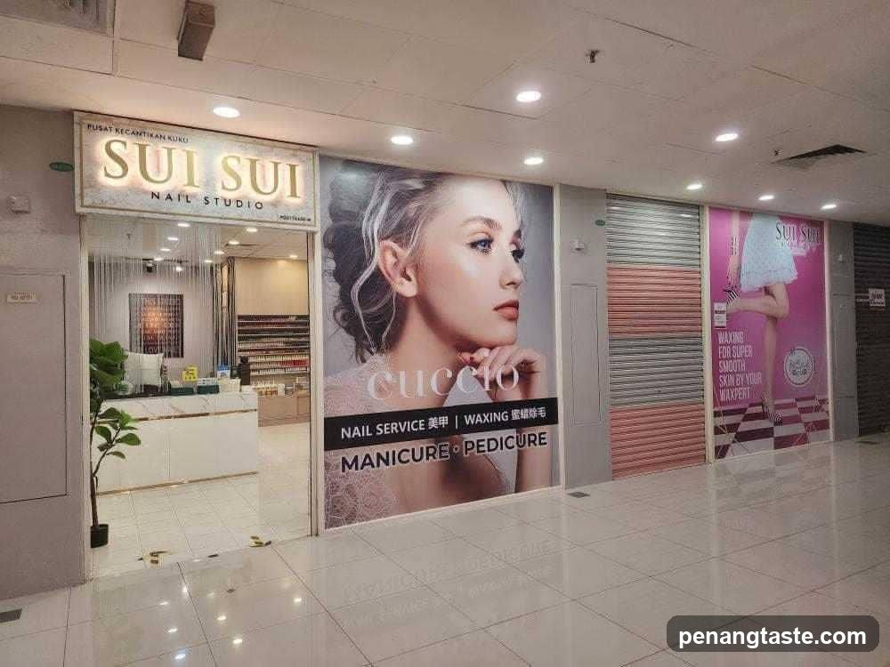 A storefront of Sui Sui Nail Studio in a mall, featuring signage with 'SUI SUI NAIL STUDIO' and promotional posters advertising manicure, pedicure, waxing services.