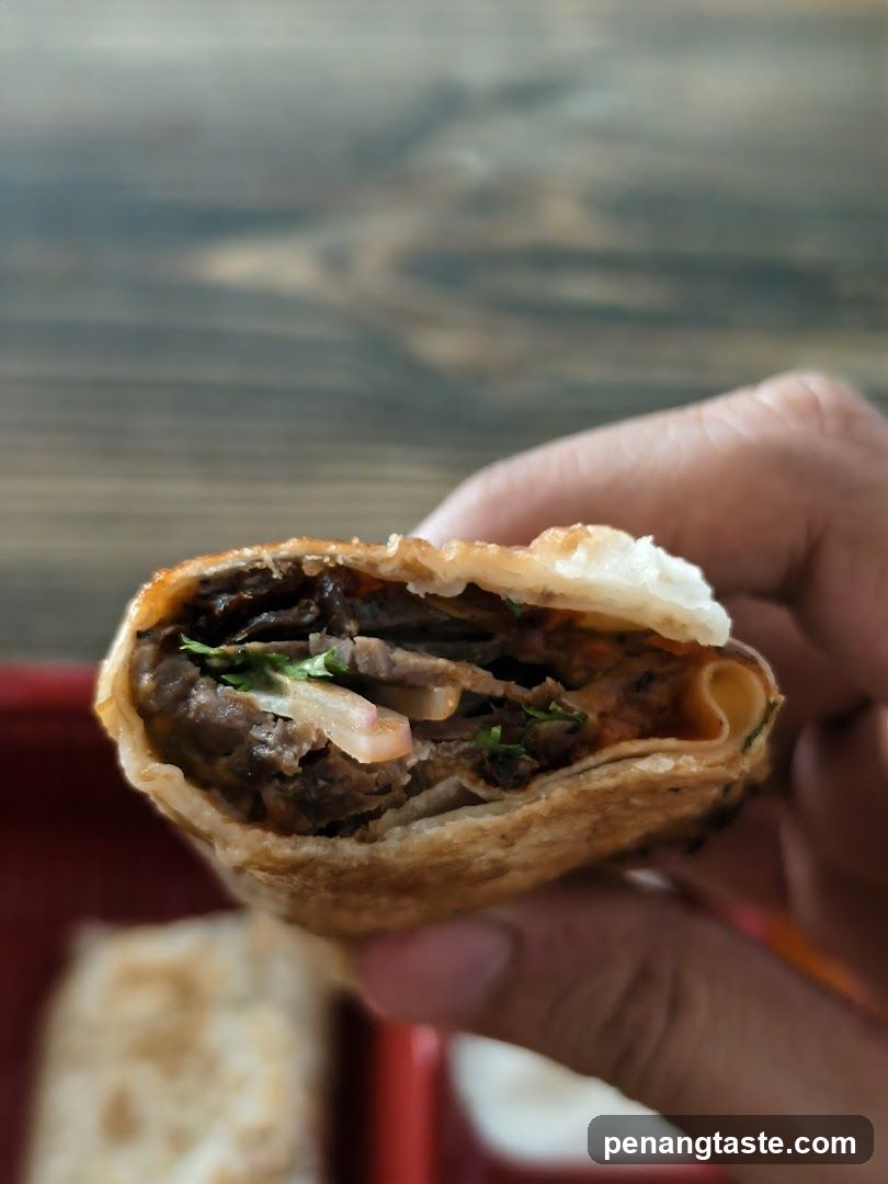 Hand holding a half-eaten wrap or sandwich