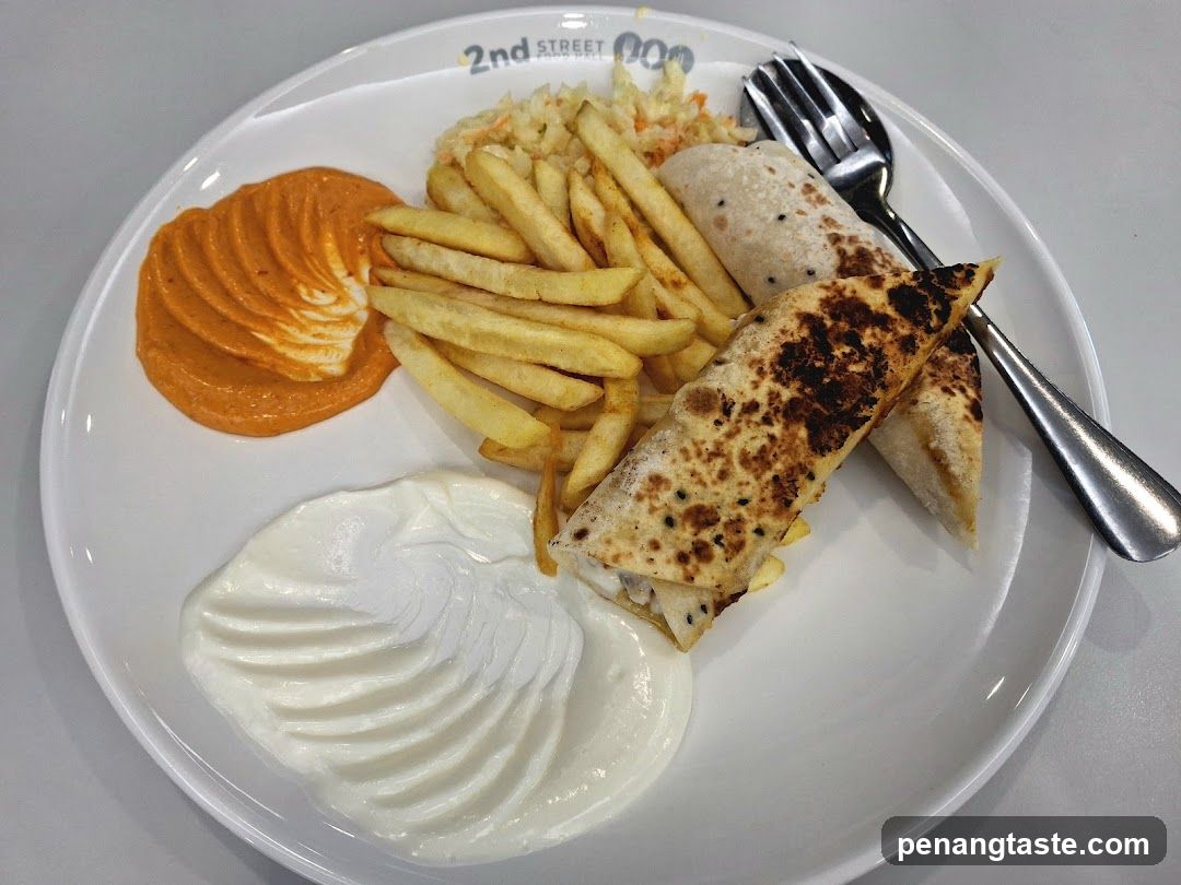 Plate of food with wrap, fries, and sauces