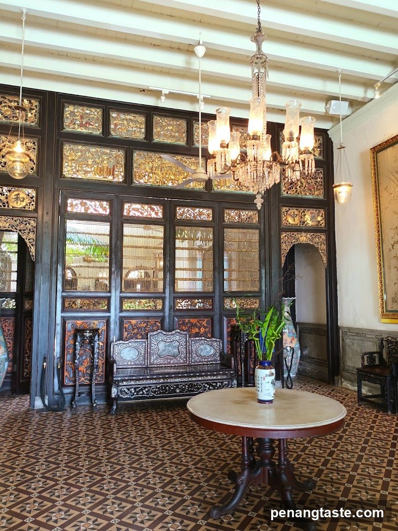 Interior of a traditional-style room with ornate wooden furniture and chandeliers.