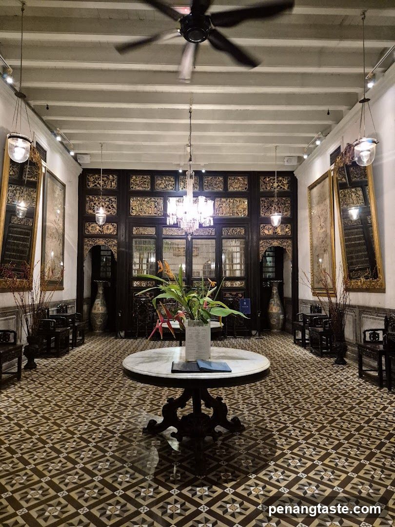 Interior of a traditional-style room with ornate wooden doors and patterned floor tiles.