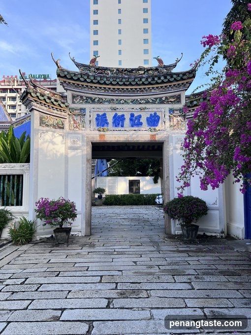 Entrance to a traditional Chinese-style gate with modern buildings in background